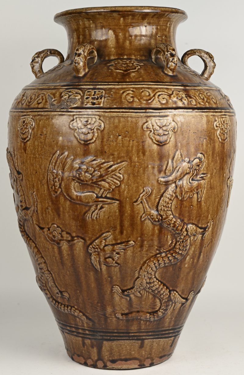 Een grote Martaban voorraadpot van bruin geglazuurd steengoed, versierd met draken en vogels in reliëf en met zes oortjes op de schouder. Zuid-Oost-Azië, omstreeks 1800. Kleine letsels.