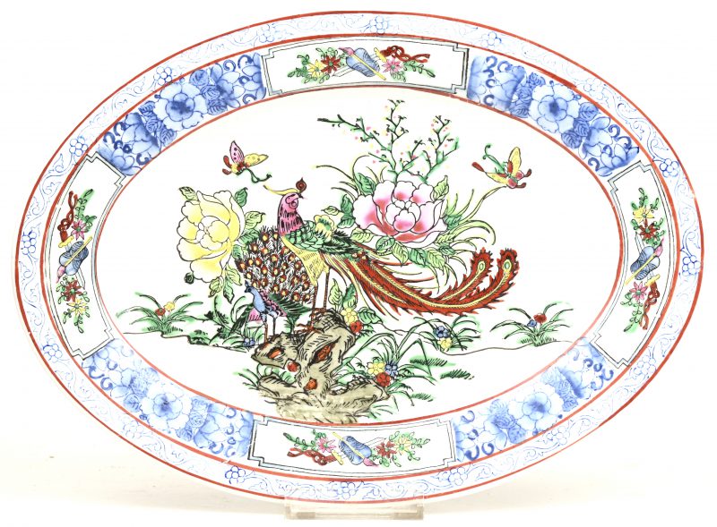Een ovaal schaaltje van Chinees porselein met een meerkleurig decor van bloemen, vogels en vlinders. Gemerkt.