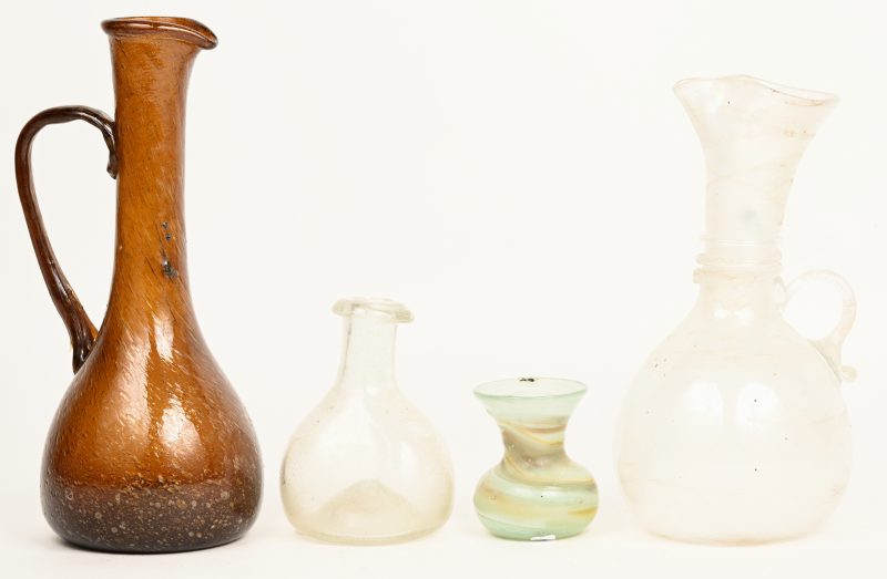 Vier diverse antieke geurflacons van geblazen glas. Het grootste met beschadiging aan hals en buik.