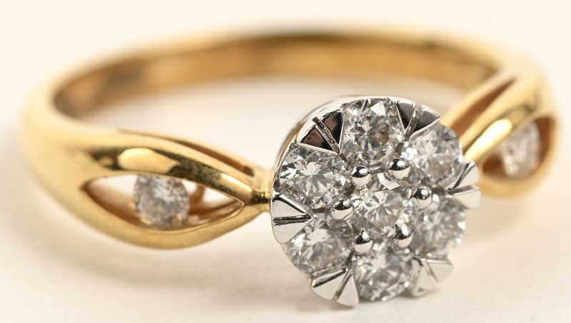 Een 18 K wit en geelgouden ring bezet met briljanten met een gezamenlijk gewicht van +- 0,50 ct.