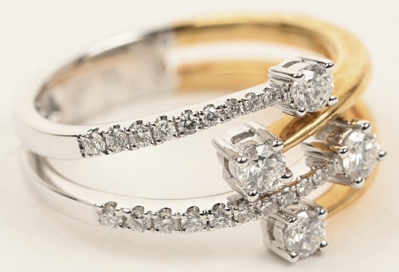 Een 18 K wit en geelgouden ring bezet met briljanten met een gezamenlijk gewicht van +- 0,46 ct.