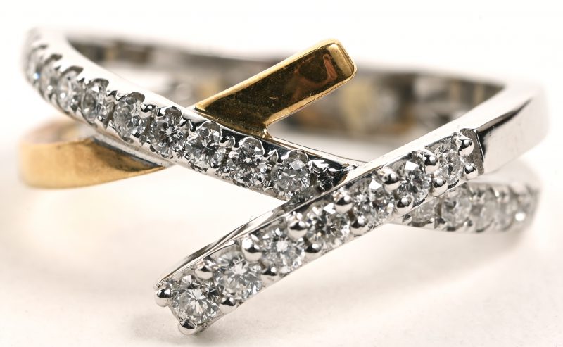 Een 18 K wit en geelgouden ring bezet met briljanten met een gezamenlijk gewicht van +- 0,45 ct.