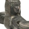 Een metalen beeldje van een liggende Egyptische met een schaal.