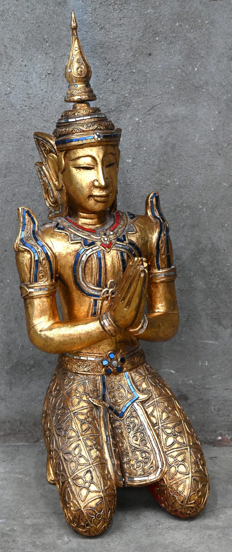 Een knielende Thaise Boeddha van verguld hout.