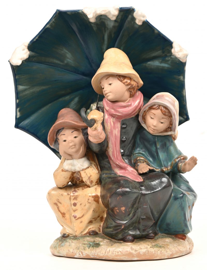 “Drie kinderen onder paraplu.” Polychroom aardewerk. Gemerkt onderaan.
