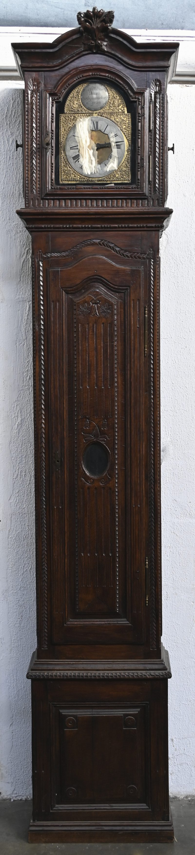 Een 19de eeuwse staande klok. Gesculpteerd notenhout. Met een werk van Wilhelmus Wessels ‘Orlogiemaeker à gelen. In werkende staat.