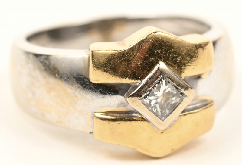 Een 18 karaats wit en geelgouden ring bezet met één diamant princes cut van +- 0,20 ct.