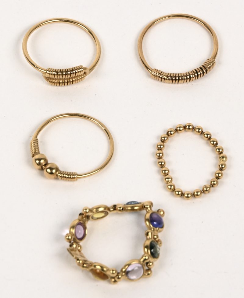 Vijf verschillende 18 karaats geelgouden ringen waarvan één bezet met half edelstenen.