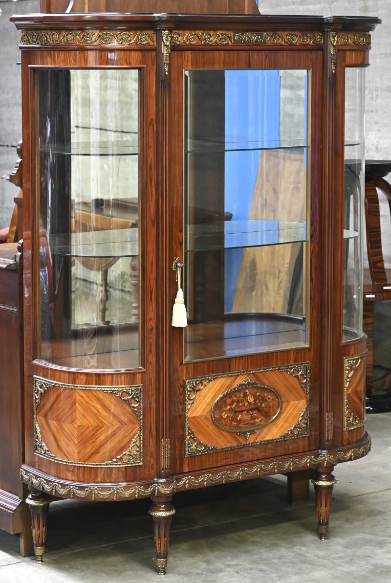 Een mid century vitrine met koperbeslag en twee bolglazen wanden.