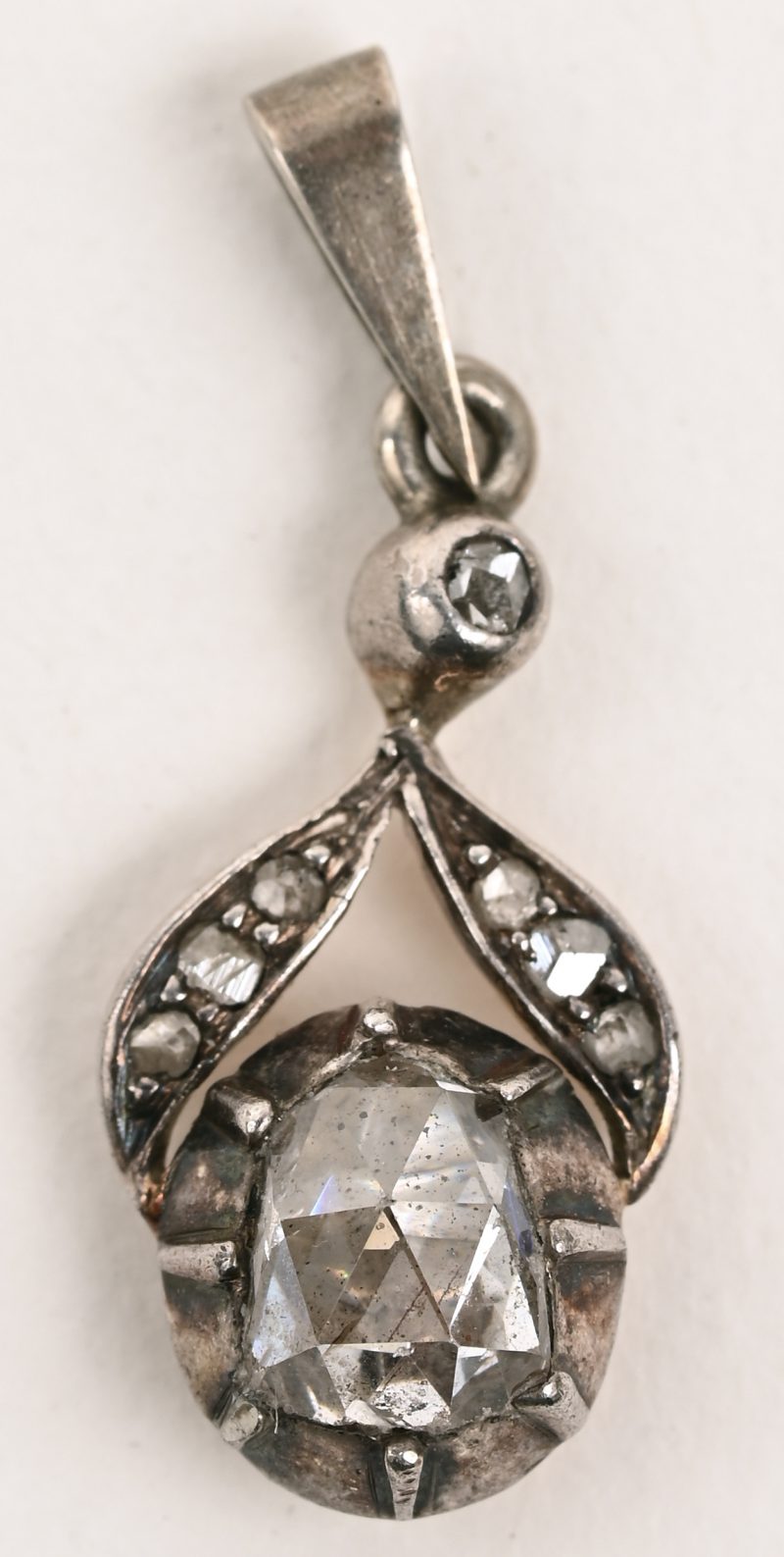 Een antiek hangertje van zilver bezet met kleine diamantjes en een centrale diamant oude slijp van +- 0,50 ct.