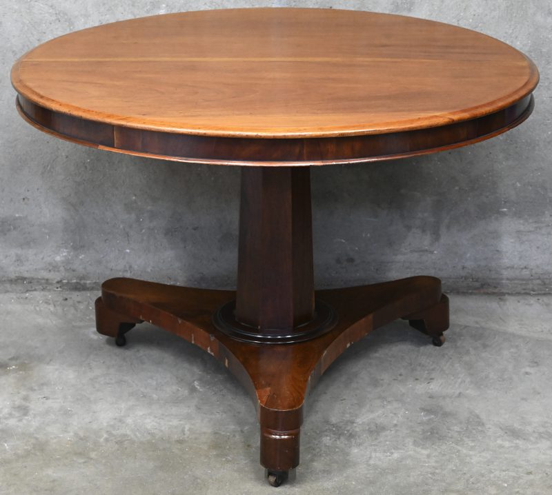 Een houten ronde tafel met centrale poot.