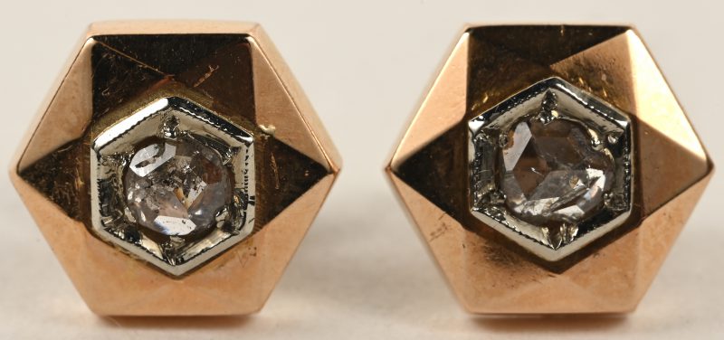Een paar 18 karaats wit en geelgouden oorbellen bezet met twee diamanten oude slijp met een gezamenlijk gewicht van +- 0,30 ct.