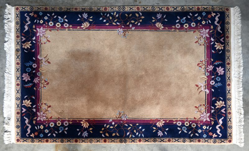 Een wollen tapijt in Chinese stijl met bloesems in het decor.