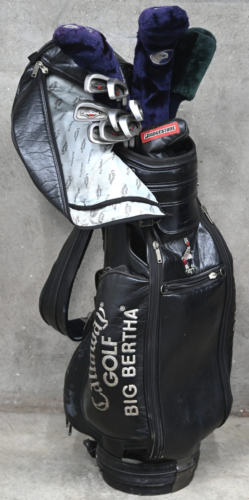 Een golftas met 12 clubs (Eén van Bridgestone), golfschoenen, handschoenen, ballen en tees.