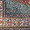 Een handgeknoopt Perzisch wollen tapijt. met in het decor een bloeiende boom met vogels.