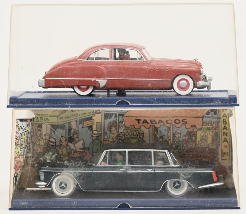 lot 2 miniatuur auto’s in display, “Kuifje”, gemerkt onderaan “Hergé-Moulinsart”.