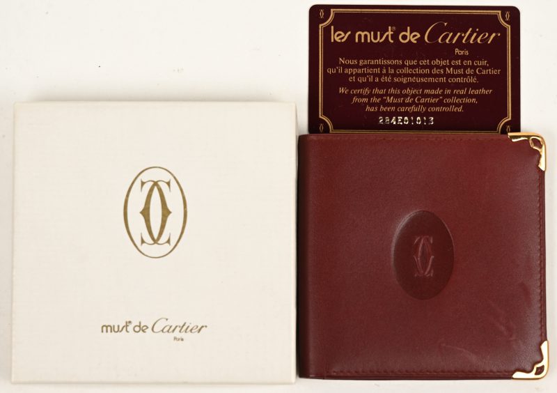 Een bruinlederen portefeuille in originele doos, met stofdoos en certificaat.