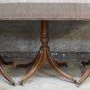 Een driedelige D-end tafel met vier armstoelen in Regency-stijl. Mahoniehout met messingen details. Engels werk.