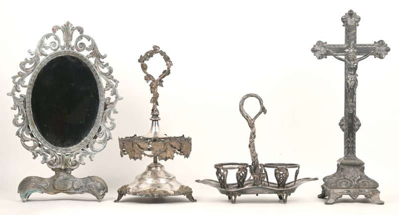 Een lot gedreven verzilverd metaal, bestaande uit een eierstaander, een olie en azijn houder (zonder glaswerk) een uitgewerkte spiegel en een crucifix.