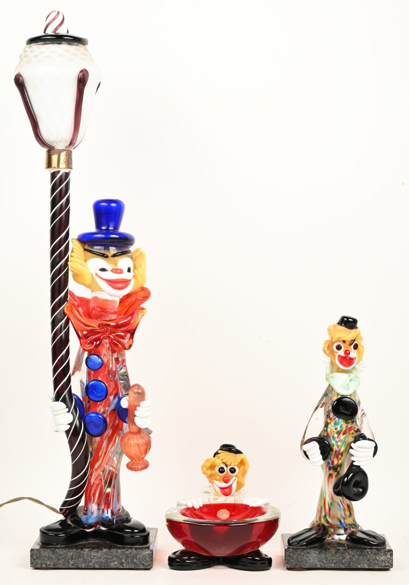 Een lot van 3 Murano clowns. Bestaande uit 1 hoge met lantaarn op arduinen voet, hetgeen als lamp funcioneert, 1 met lichaam als schaaltje en 1 standaard type op arduinen voet.