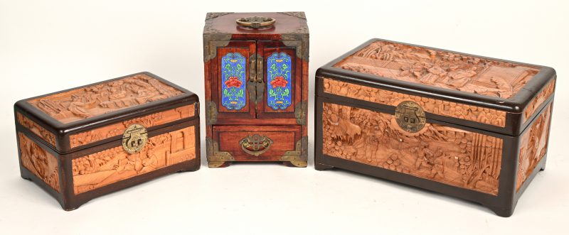 Een lot van 2 Chinese opbergkistjes met houtsnijwerk en slot. Bijgevoegd, een klein sieradenkastje met 4 laden, versierd met diverse ornamenten.