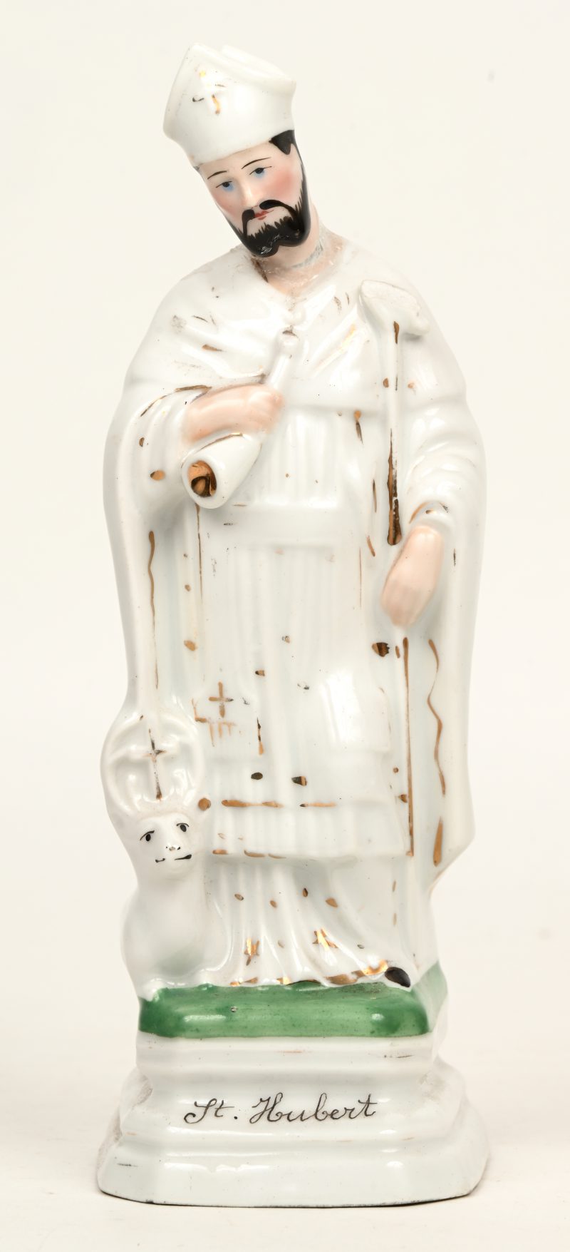 Een onthoofd porseleinen beeldje van St. Hubert. Lijmsporen door breuk-en herstelschade thv het hoofd.