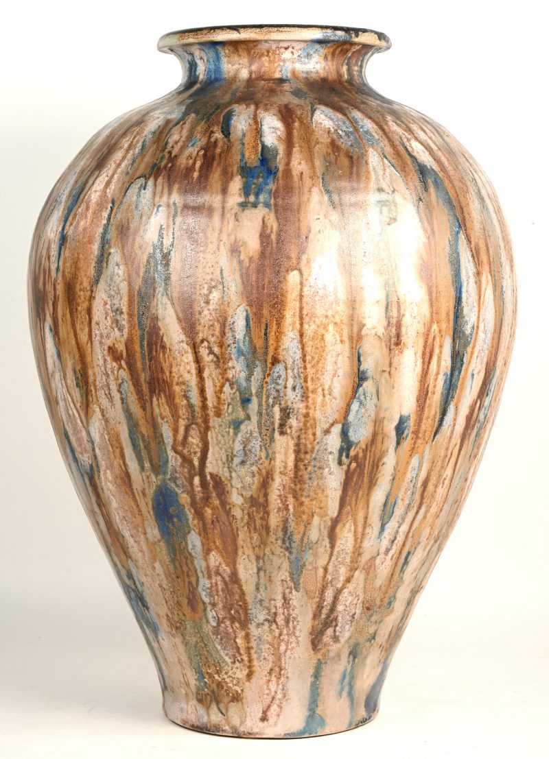 Een aardewerken bolle vaas met bruin en blauw glazuur.