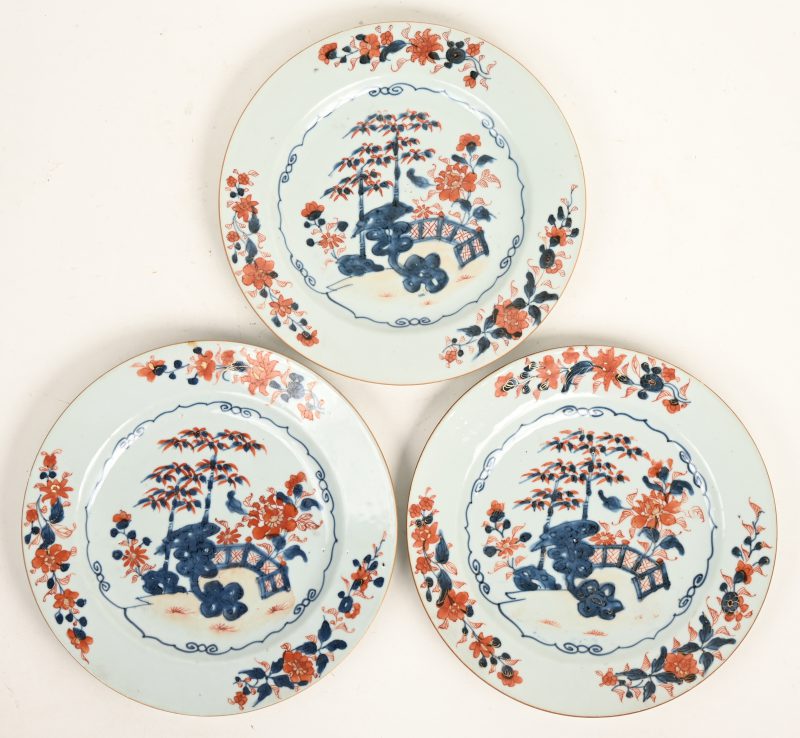 Drie borden van Chinees porselein met een decor van een prieel in rood, blauw en goud naar Japans voorbeeld. XIXde eeuw.