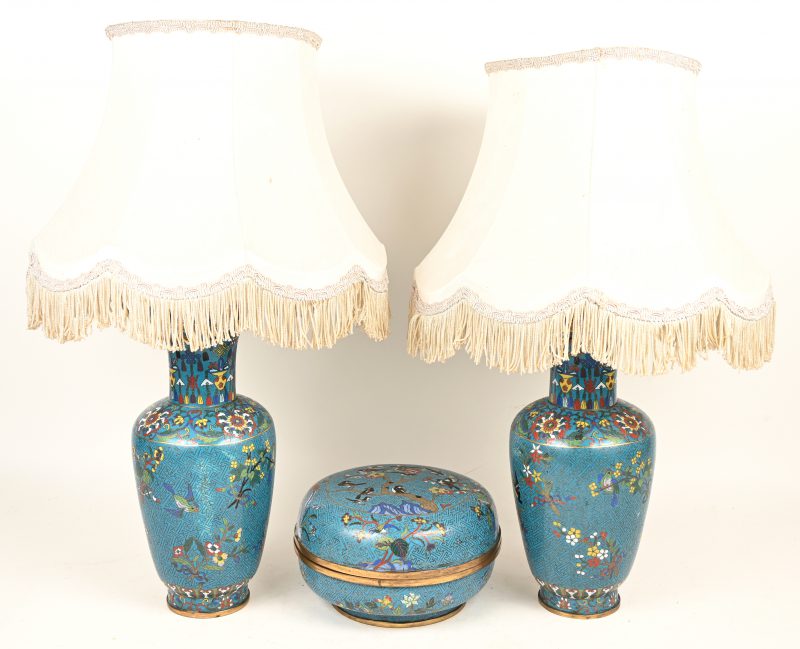 Een lot blauw cloisonné bestaande uit twee vazen als lamp gemonteerd en een dekseldoos te gebruiken als twee schalen. Gedecoreerd met paradijsvogels.