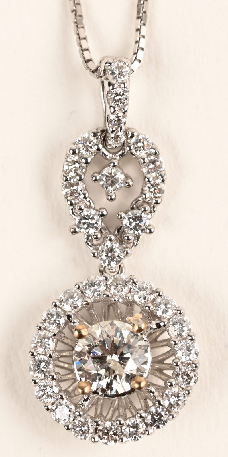 Een 18 karaats witgouden ketting met hanger bezet met een centrale diamant van +- 0,39 ct. en briljanten met een gezamenlijk gewicht van +- 0,35 ct.
