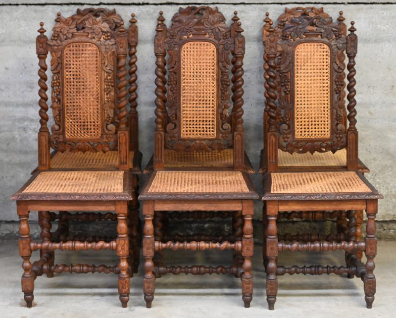 Een lot van 6 eikenhouten stoelen met detail snijwerk, rieten zit-en rugvlak en gedraaide poten.