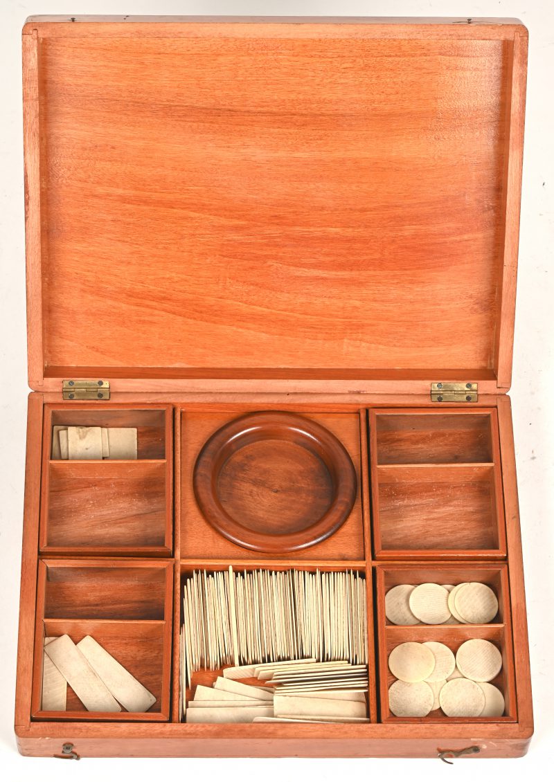 Een houten kistje met speelchips, dewelke in rond en rechthoekige vorm.
