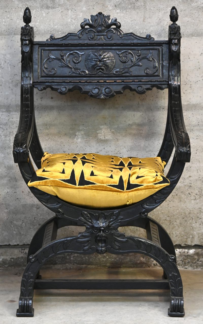 Een houten Dagobert stoel met goud zwart kussen. Divers ornament en patroon snijwerk.