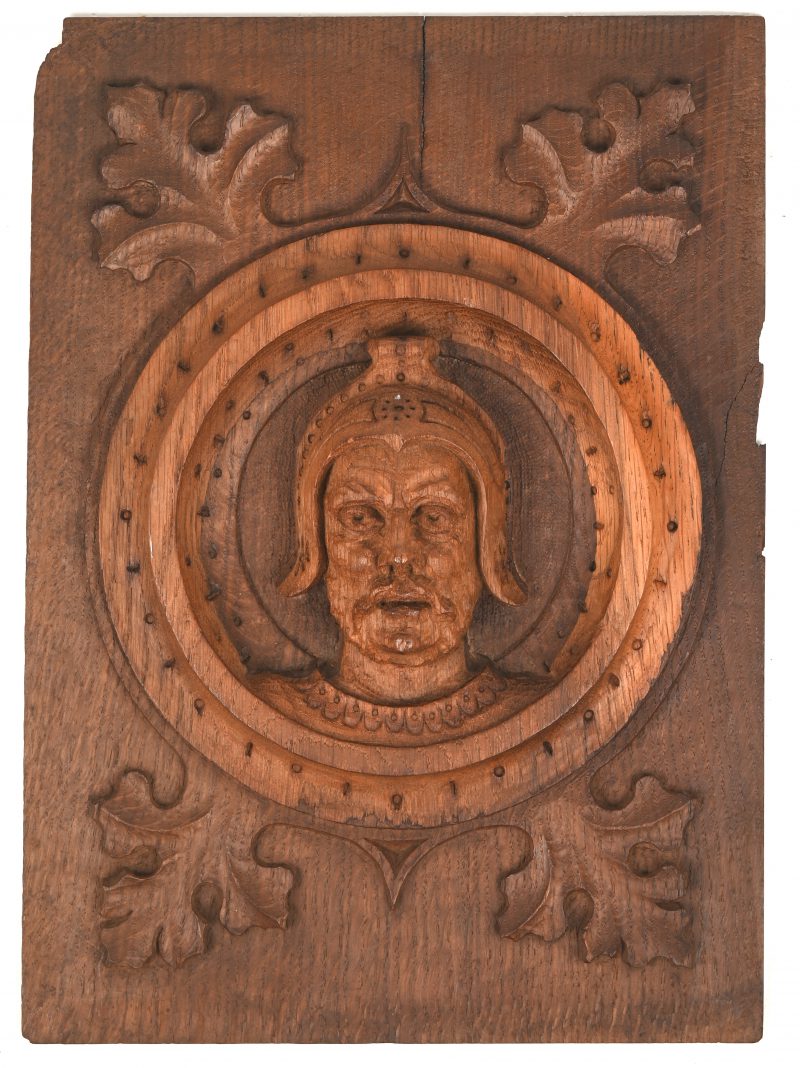 Een houten paneel met gesculpteerd profiel van een man.