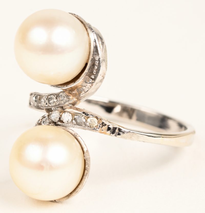 “Toi et Moi”. Een 18 karaat witgouden ring bezet met briljanten met een gezamenlijk gewicht van +- 0,10 ct. en twee parels.