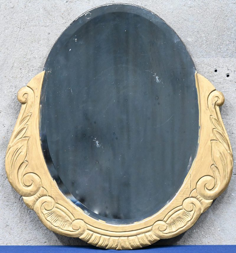 Een ovalen houten spiegel.