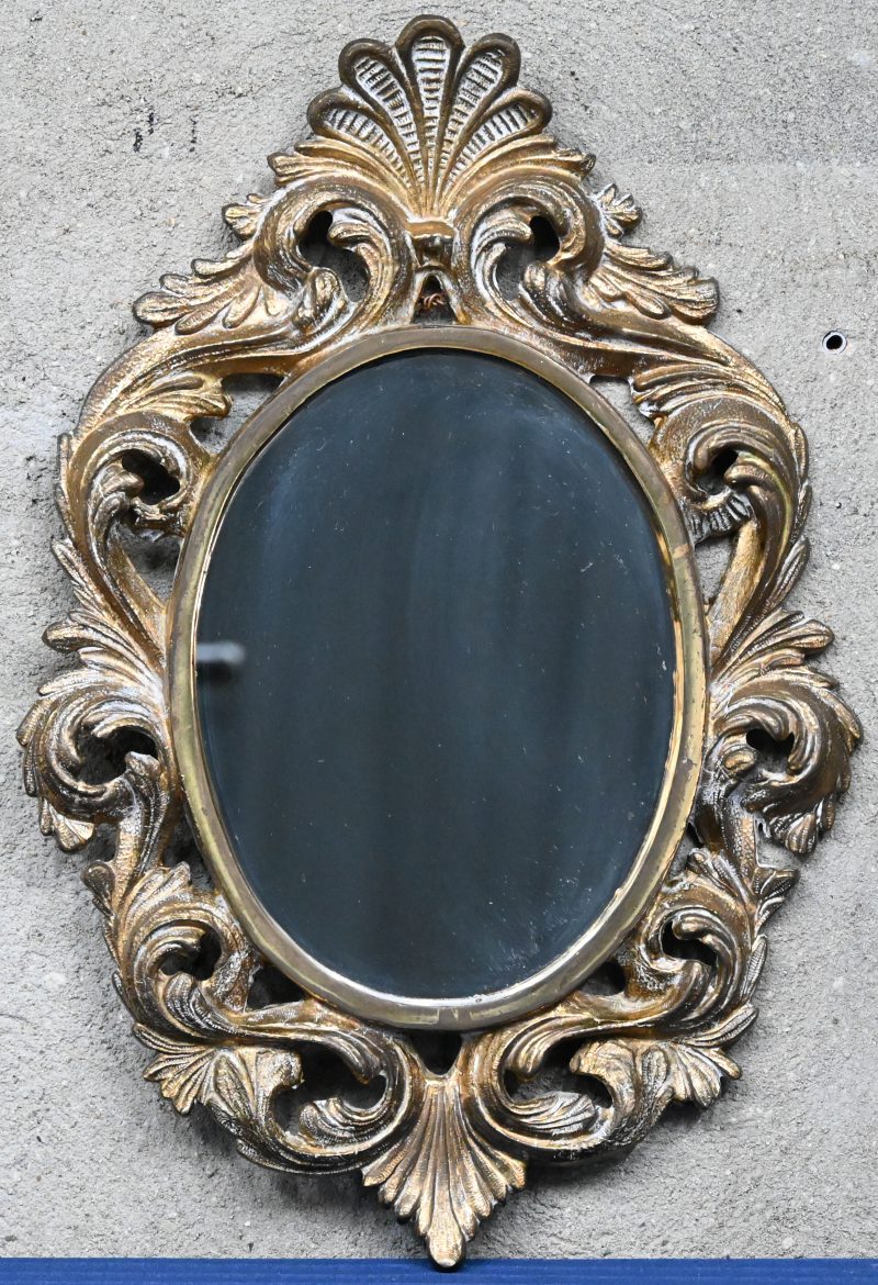 Een ovale spiegel van ijzer versierd met acantusbladen rondom.