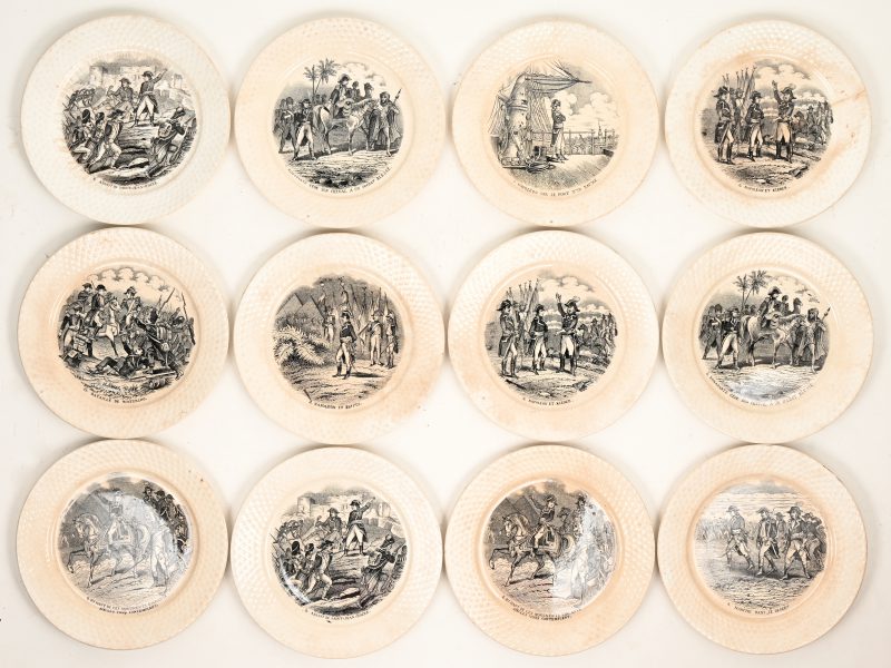 Een serie van twaalf aardewerken dessertborden met decors uit de campagnes van Napoleon I. Randen in vlechtwerkimitatie. Onderaan gemerkt, omstreeks 1900.