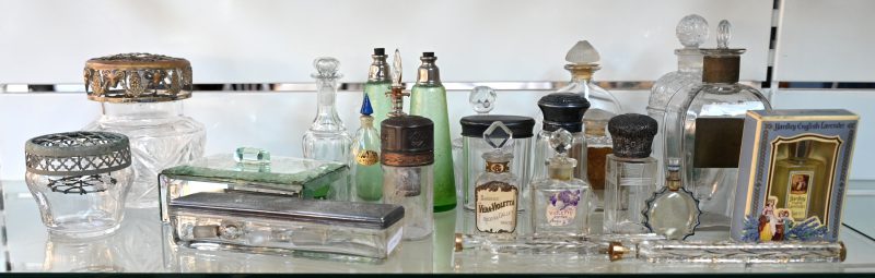 Een lot glas en kristal bestaande uit parfum flacons, karaffen, twee dekseldoosjes en twee pique-fleurs.