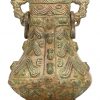Een Chinees brons gesculpteerde “Zun” vaas. Op houten sokkel, met diverse sculpturen afgebeeld en drakenhoofden als oren.