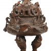 Een grote Chinees bronzen koro. Wierookvat met grote draak op deksel en diverse zeedieren afgebeeld. Op houten sokkel en gesteund door 3 visvormige poten. 19/20e eeuw. Kleine barst onderin ketel door verweer.