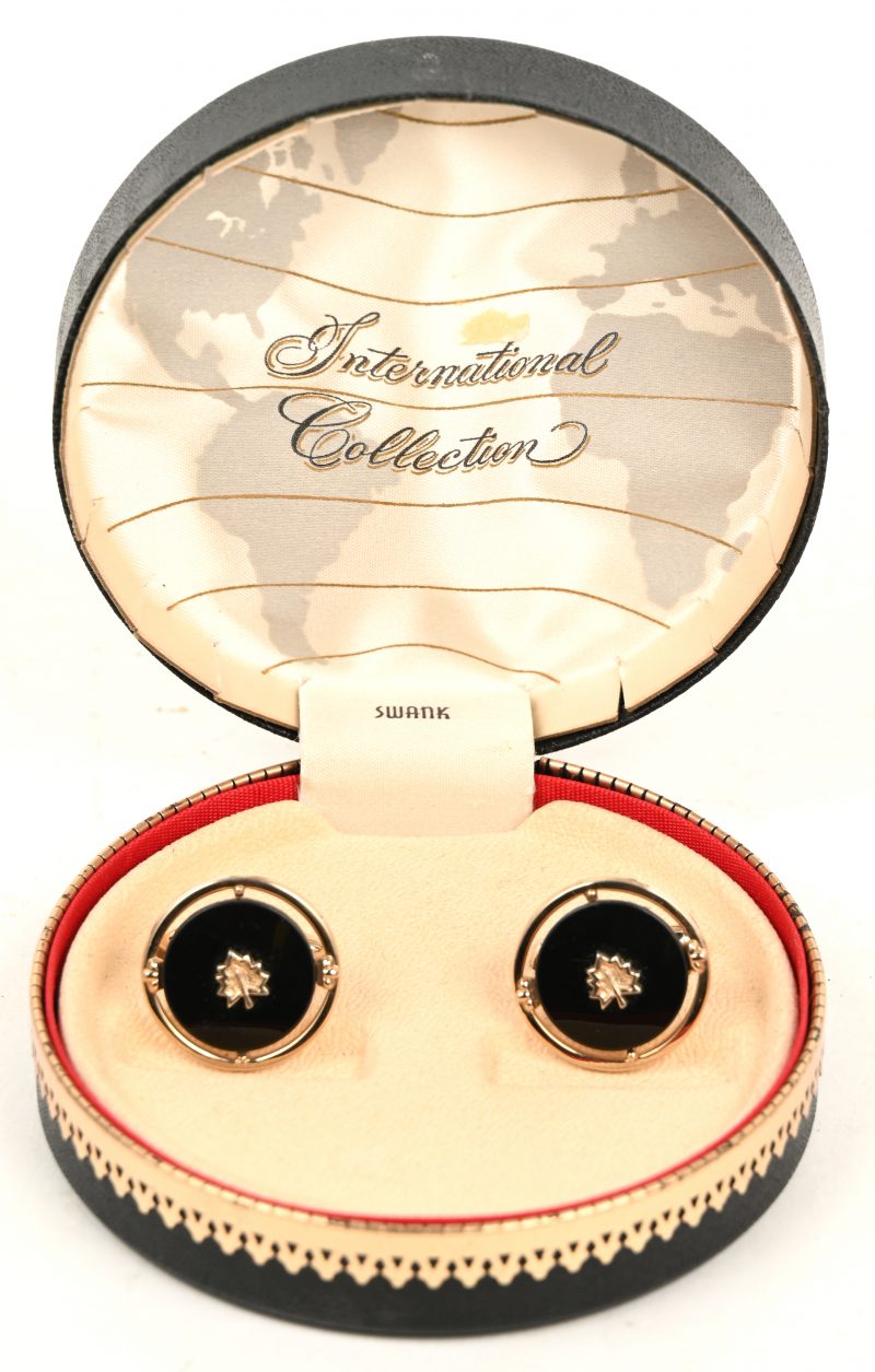 Een paar “Swank” manchetknopen - International Collection. In een rond doosje met vergulde elementen en hoofd ornament op cover.