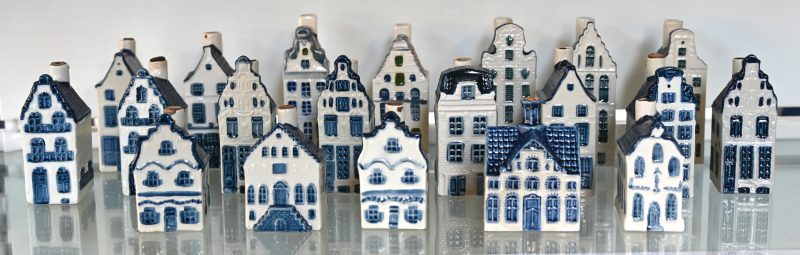20 Amsterdamse huisjes van blauw en wit Delfts aardewerk, uitgegeven door Bols als jeneverflesjes voor KLM, sommige nog afgesloten.