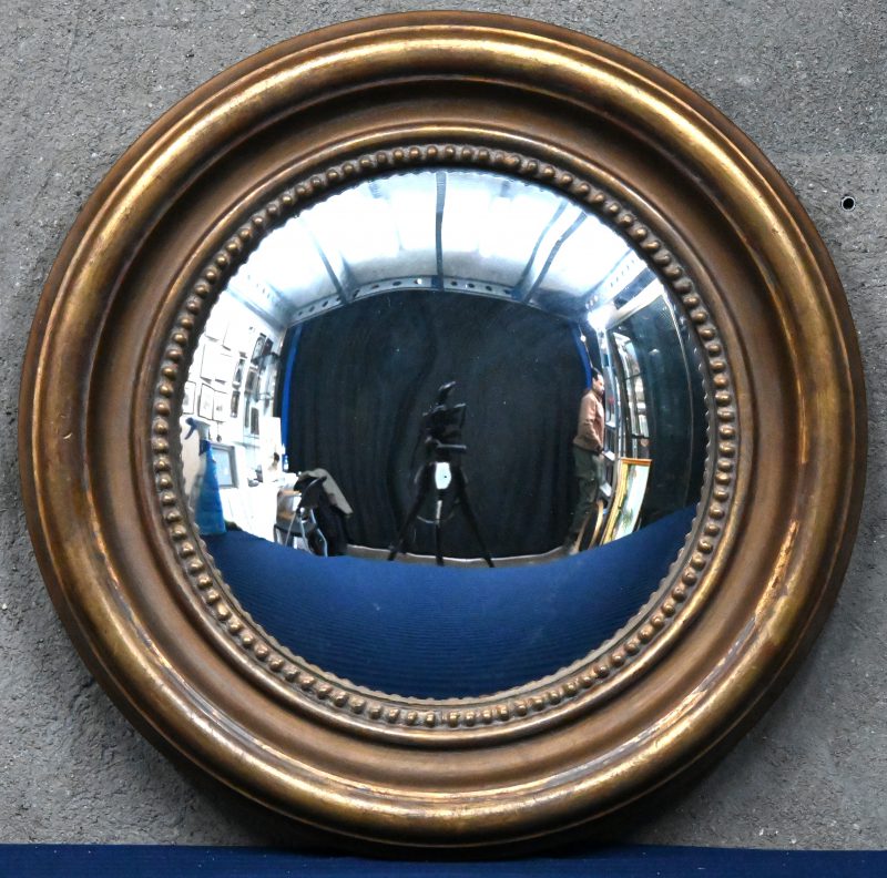 Een butler spiegel, met bolle vorm in vergulde kader.