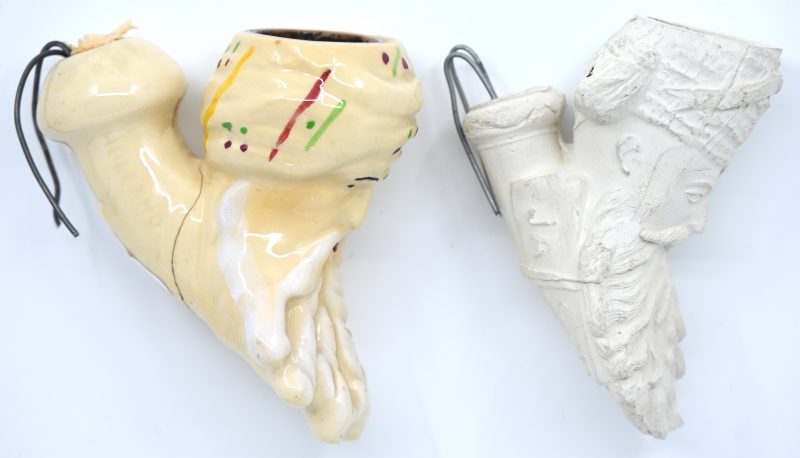 Een Jacob-stijl pijpenkop van geglazuurd aardewerk (haarbarst) en een soortgelijke van pijpaarde, gemerkt Jacob en met eveneens een haarlijn naar boven toe.