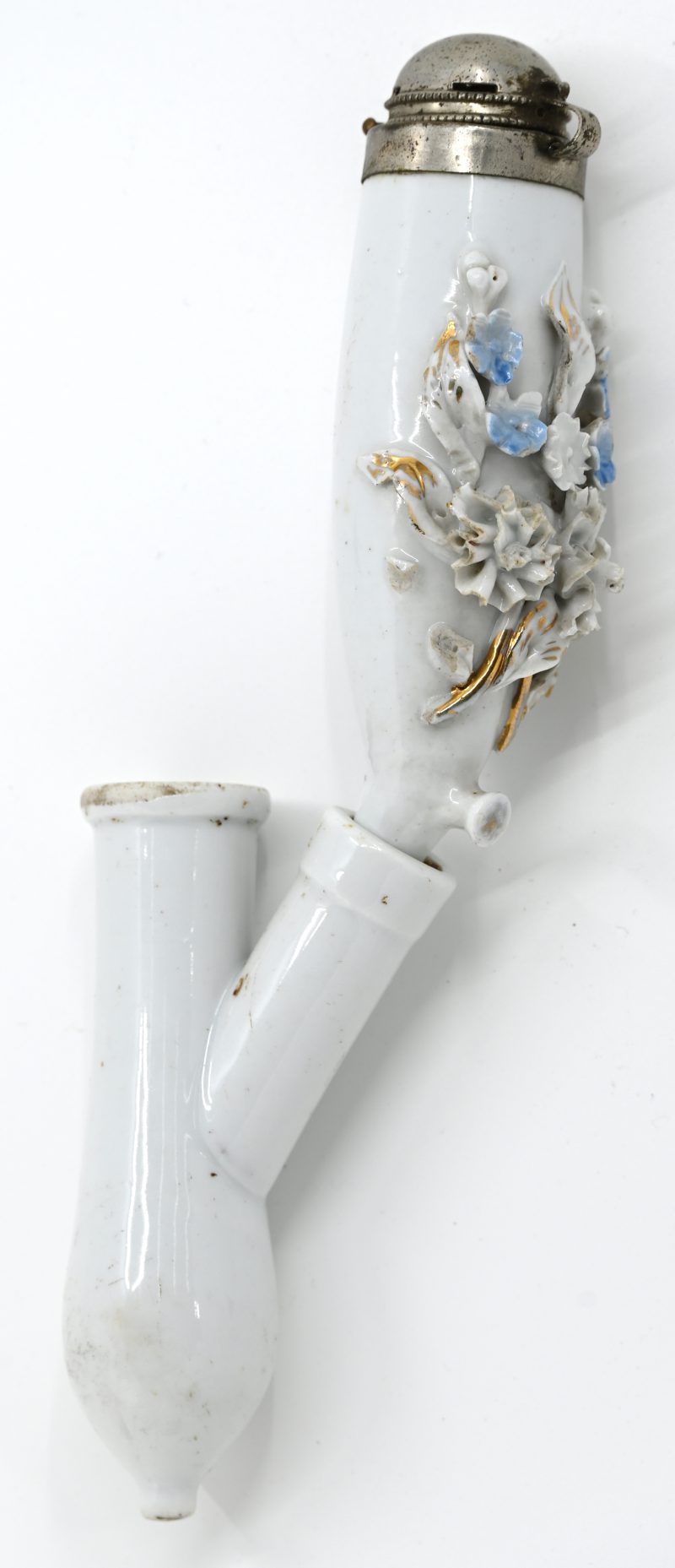 Een grote pijpenkop en vochtsluis van porselein, versierd met een veelkleurige bloementuil in reliëf. Metalen deksel.