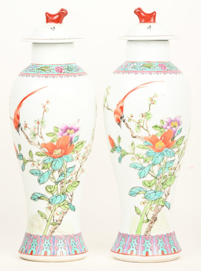 Een paar smal Chinees porseleinen vazen met meerkleurig decor, naar famille rose. Onderaan gemerkt.