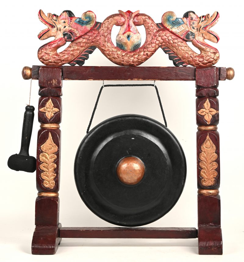 Een Balinese “healing” gong in hout gesculpteerd frame met draken ornament bovenaan.