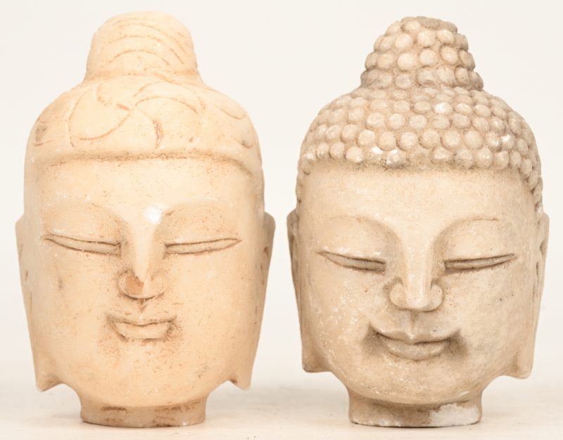 Een lot van twee stenen Boeddha beeld hoofden.