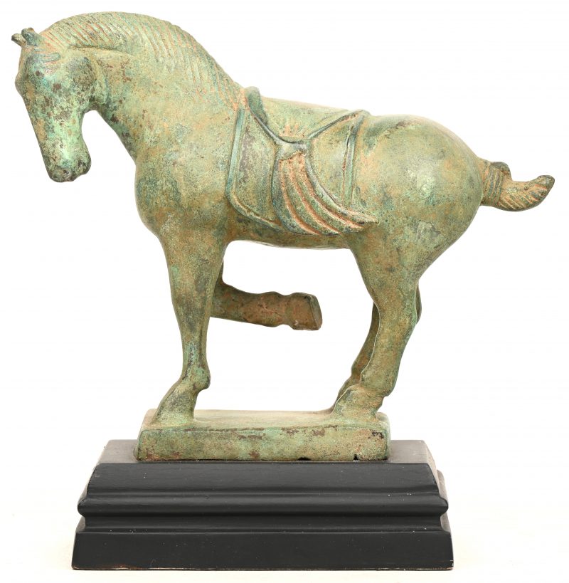 Een brons gesculptuurd beeld van een gezadeld paard.